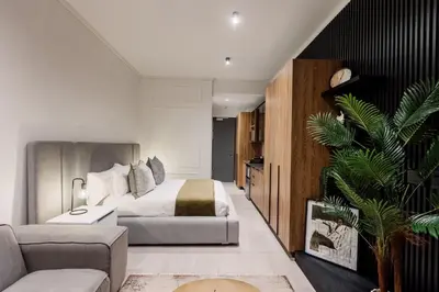 a bedroom with a king sized bed and a plant at Modern & Peaceful Studio in Pretoria