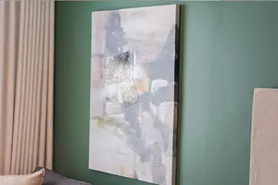 a painting hanging on a green wall next to a lamp at Capital City Luxury Apartment 830 Menlyn Maine in Pretoria