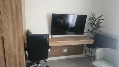 a television sitting on a wooden desk with a chair at Capital City Luxury Apartment 830 Menlyn Maine in Pretoria