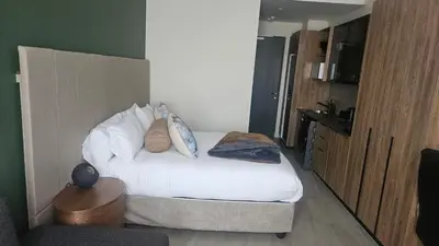 a hotel room with a bed with pillows on it at Capital City Luxury Apartment 830 Menlyn Maine in Pretoria