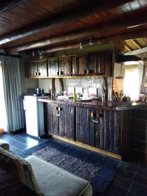 a kitchen with wooden cabinets and a refrigerator at Mafuta Lodge - Mabalingwe Nature Reserve in Warmbaths