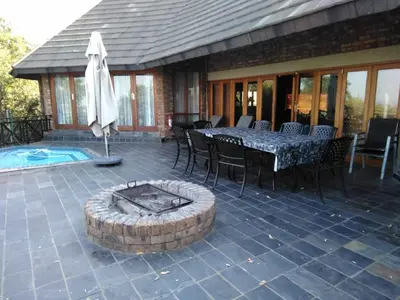 a patio with a table and chairs and a fire pit at Mafuta Lodge - Mabalingwe Nature Reserve in Warmbaths