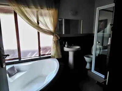 a bathroom with a tub and a sink and a window at Mafuta Lodge - Mabalingwe Nature Reserve in Warmbaths