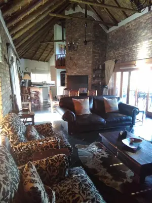 a living room with leather couches and a fireplace at Mafuta Lodge - Mabalingwe Nature Reserve in Warmbaths