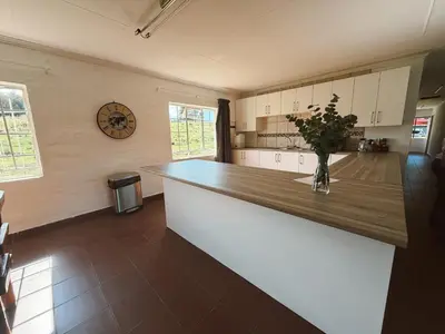 a kitchen with a counter with a vase of flowers at Rooikrans Guest House Mpumalanga in Boschfontein