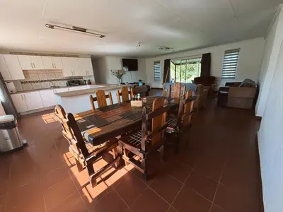 a dining room and kitchen with a table and chairs at Rooikrans Guest House Mpumalanga in Boschfontein