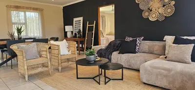 a living room with a couch and chairs and a table at Rupping Bush Retreats in Mmukubyane
