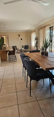 a living room with a wooden table and chairs at Rupping Bush Retreats in Mmukubyane