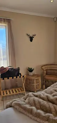 a bedroom with two beds and a antlers on the wall at Rupping Bush Retreats in Mmukubyane