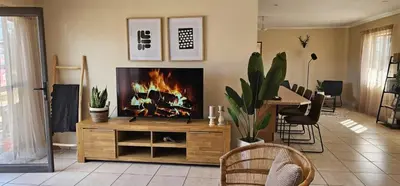 a living room with a fireplace in the center at Rupping Bush Retreats in Mmukubyane