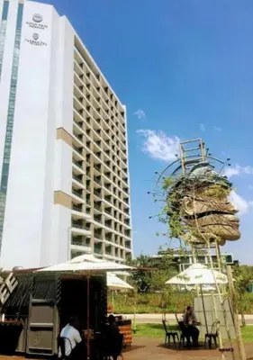 a tall white building with a large building at Modern Studio in Menlyn Maine in Pretoria