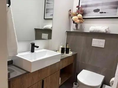 a bathroom with a white sink and a toilet at Modern Studio in Menlyn Maine in Pretoria