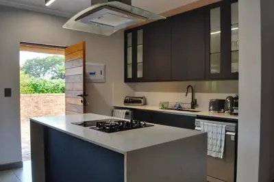 a kitchen with black cabinets and a stove top oven at Kruger Park Lodge Unit 268 & Unit 531 in Hazyview
