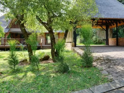 a garden with trees and plants in front of a house at Kruger Park Lodge Unit 268 & Unit 531 in Hazyview