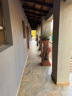 a hallway with benches and a plant in a vase at Kioma guest house mahwelereng in Mokopane