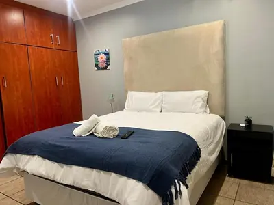 a bedroom with a bed with a blue blanket at De'Lush Oasis in Pretoria