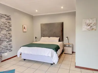 a bedroom with a large bed in a room at De'Lush Oasis in Pretoria