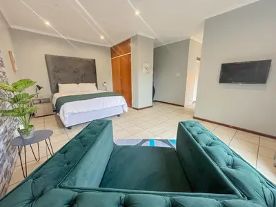 a living room with a couch and a bed at De'Lush Oasis in Pretoria