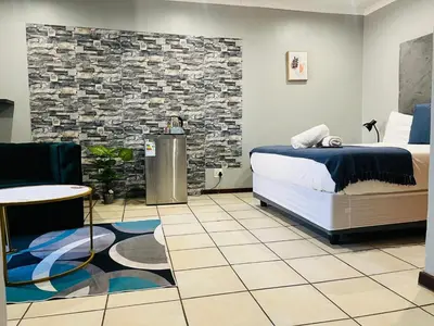 a bedroom with a bed and a stone wall at De'Lush Oasis in Pretoria