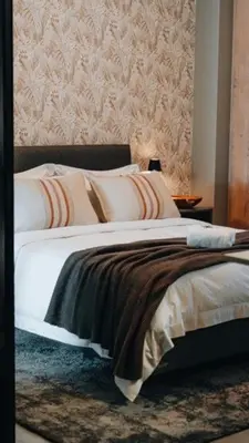 a bedroom with a bed with white sheets and pillows at Urban Gem on 18th Prime Location in Pretoria