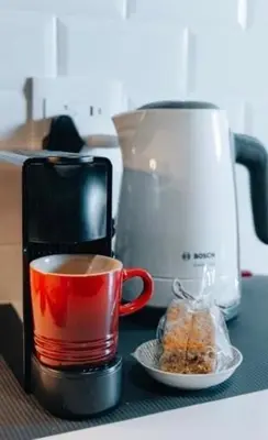 a cup of coffee on a counter next to a blender at Urban Gem on 18th Prime Location in Pretoria