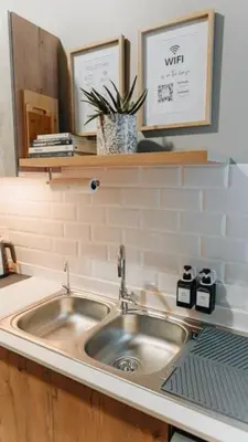 a sink in a kitchen with a mirror and a plant at Urban Gem on 18th Prime Location in Pretoria