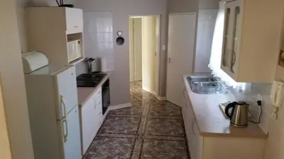 a small kitchen with a sink and a microwave at Royal Ridge Guesthouse in Pretoria