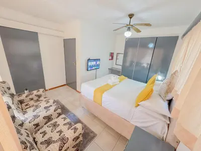 a bedroom with a bed and a couch at Berry Bliss Haven in Pretoria