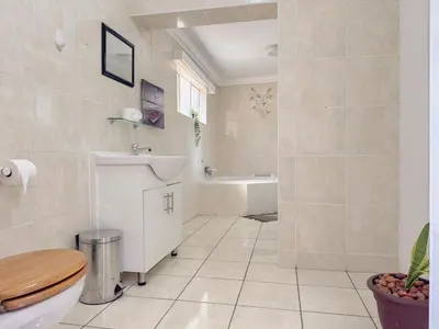 a bathroom with a toilet and a sink and a tub at Berry Bliss Haven in Pretoria