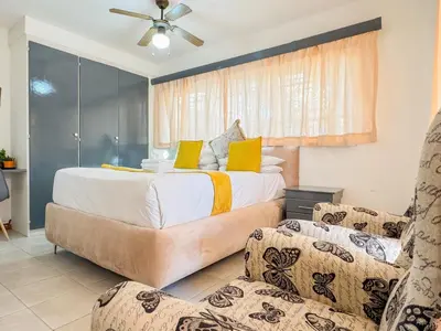 a bedroom with a large bed and two chairs at Berry Bliss Haven in Pretoria