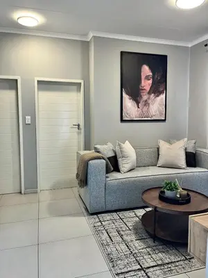 a living room with a couch and a table at Kurhula Suite Apartment in midrand in Midrand
