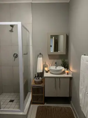 a bathroom with a sink and a shower at Kurhula Suite Apartment in midrand in Midrand