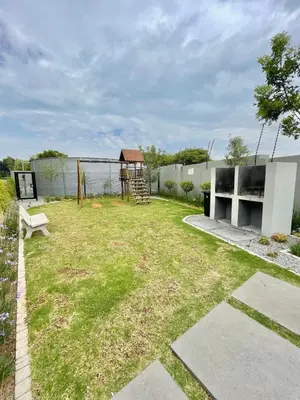 a garden with a bench and a playground at Kurhula Suite Apartment in midrand in Midrand