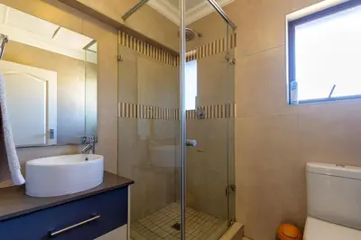 a bathroom with a sink and a glass shower at Alimamaspaces The Mansons Riverbend Midrand in Midrand