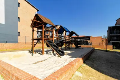 a group of playground equipment in front of a building at AlimamaSpaces Bonitos Waterfall Ridge in Midrand