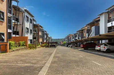 an empty street with buildings and cars parked on it at AlimamaSpaces Bonitos Waterfall Ridge in Midrand