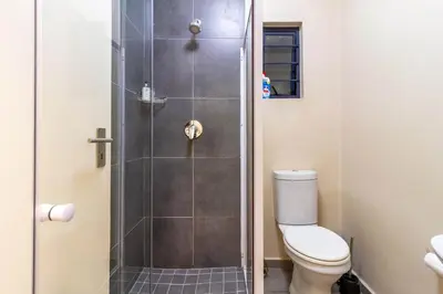 a bathroom with a shower with a toilet at AlimamaSpaces Bonitos Waterfall Ridge in Midrand