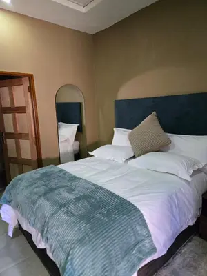 a bedroom with a large bed with a blue headboard at Cozy Lifestyle Guesthouse in Naboomspruit