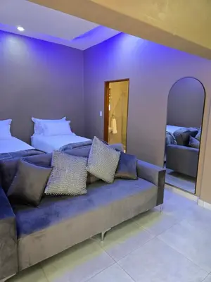 a living room with a couch and two beds at Cozy Lifestyle Guesthouse in Naboomspruit