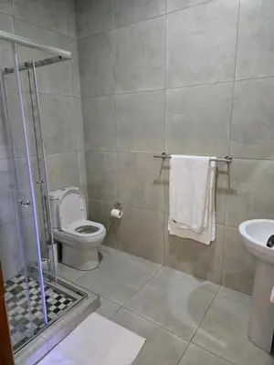 a bathroom with a shower and a toilet and a sink at Cozy Lifestyle Guesthouse in Naboomspruit