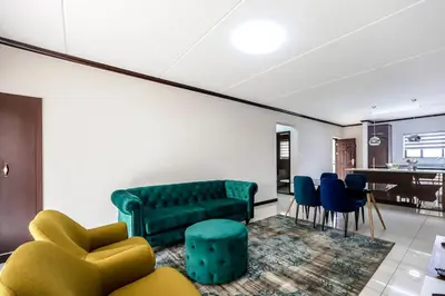 a living room with a green couch and chairs at AlimamaSpaces The Manson's Walford in Midrand