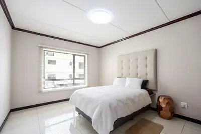 a bedroom with a large bed and a window at AlimamaSpaces The Manson's Walford in Midrand