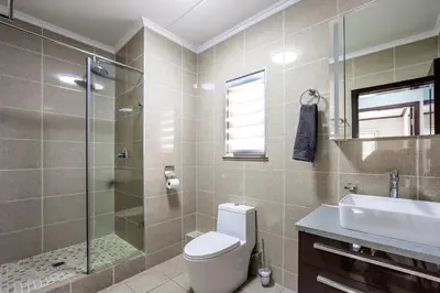 a bathroom with a toilet and a shower and a sink at AlimamaSpaces The Manson's Walford in Midrand