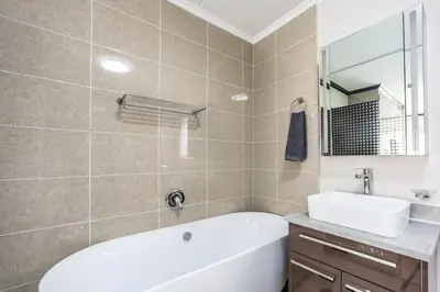 a bathroom with a white tub and a sink at AlimamaSpaces The Manson's Walford in Midrand