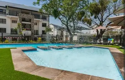 a large swimming pool in front of a building at AlimamaSpaces The Chelsea's Kikuyu in Midrand