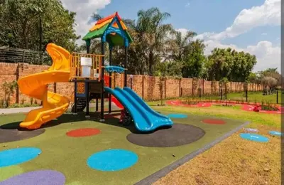 a playground with a slide in a park at AlimamaSpaces The Chelsea's Kikuyu in Midrand