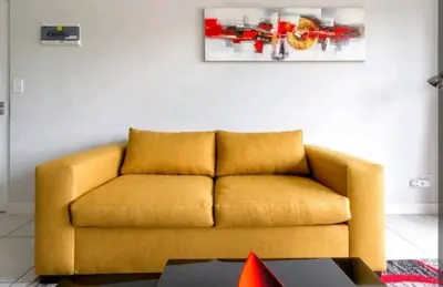 a yellow couch in a living room with a table at AlimamaSpaces The Chelsea's Kikuyu in Midrand
