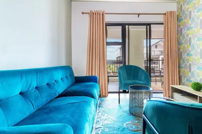 a living room with a blue couch and chairs at AlimamaSpaces The Munyakas Manson 1543 in Midrand