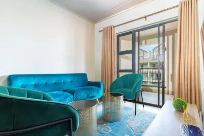 a living room with a blue couch and chairs at AlimamaSpaces The Munyakas Manson 1543 in Midrand