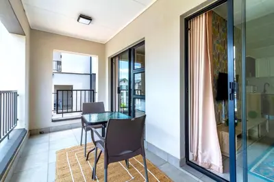 a dining room with a glass table and chairs at AlimamaSpaces The Munyakas Manson 1543 in Midrand